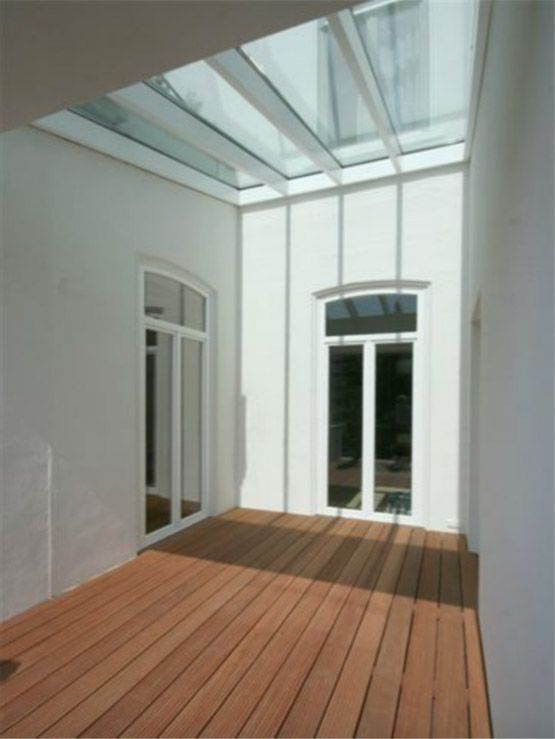 Ein Raum mit Glasdach und Holzboden