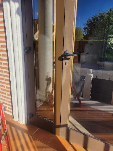 Una puerta con una cadena alrededor está abierta a un balcón.