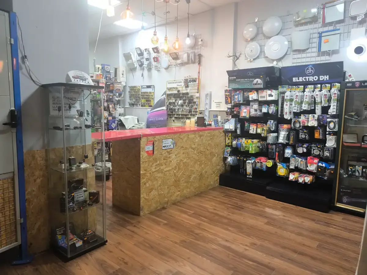 Hombre con camisa azul, abriendo una puerta verde con herrajes de latón.