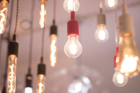 Mano girando un pomo de latón en una puerta gris oscuro.