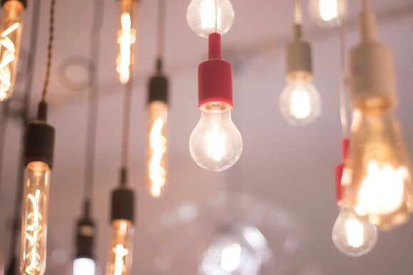 Bombillas colgando del techo, algunas encendidas. Iluminación de tonos cálidos.
