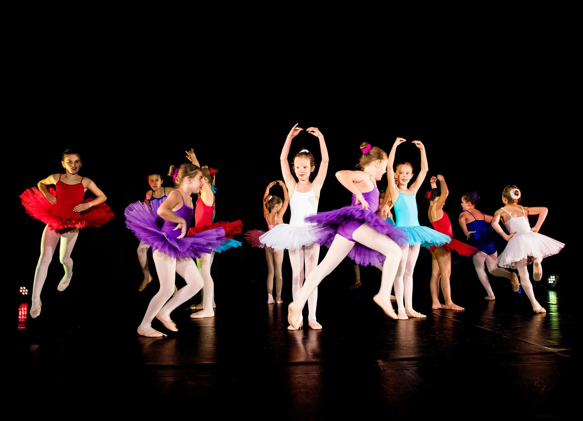Eine Gruppe junger Ballerinas tritt auf einer Bühne auf.