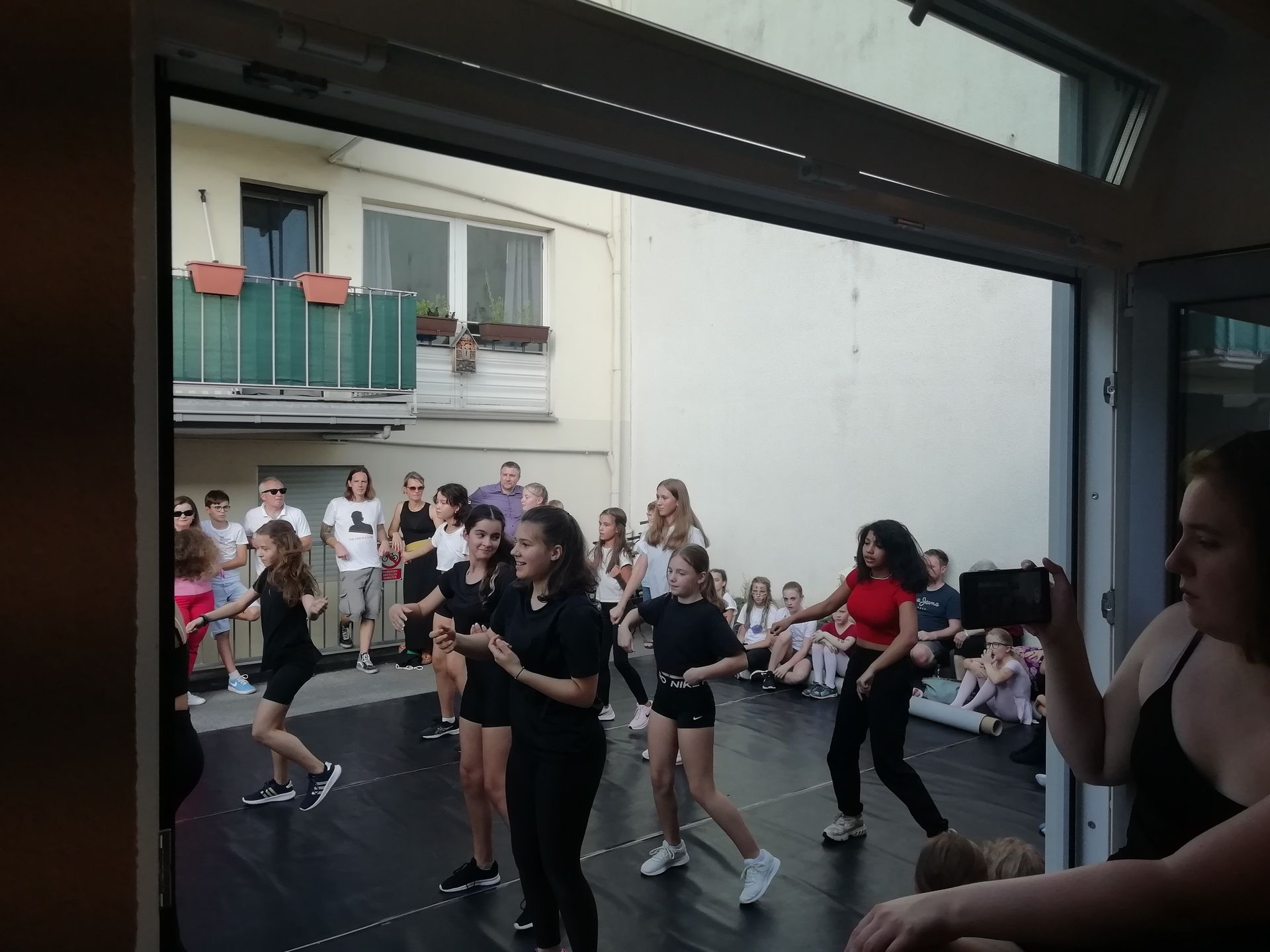 Eine Gruppe junger Mädchen tanzt vor einer Menschenmenge.