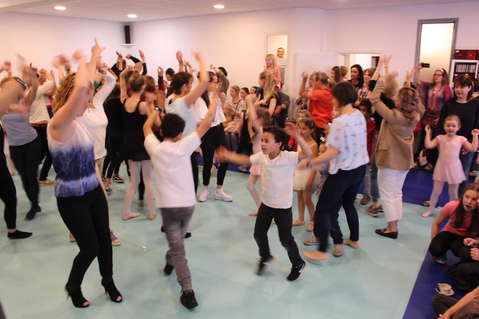 Eine große Gruppe von Menschen tanzt in einem Raum.