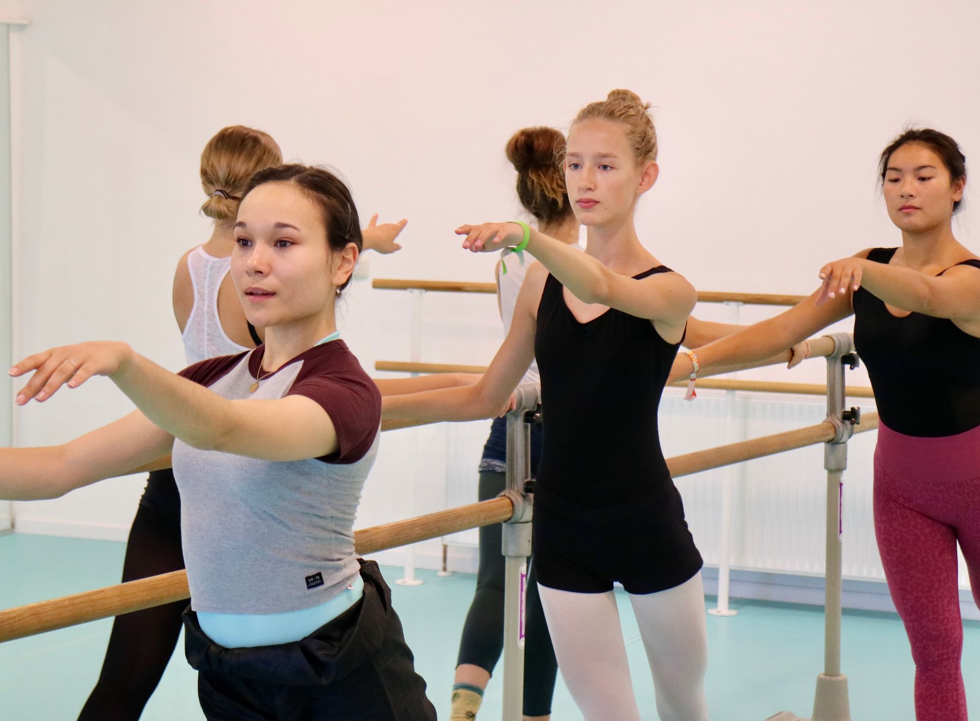 Eine Gruppe junger Frauen übt Ballett in einem Tanzstudio.