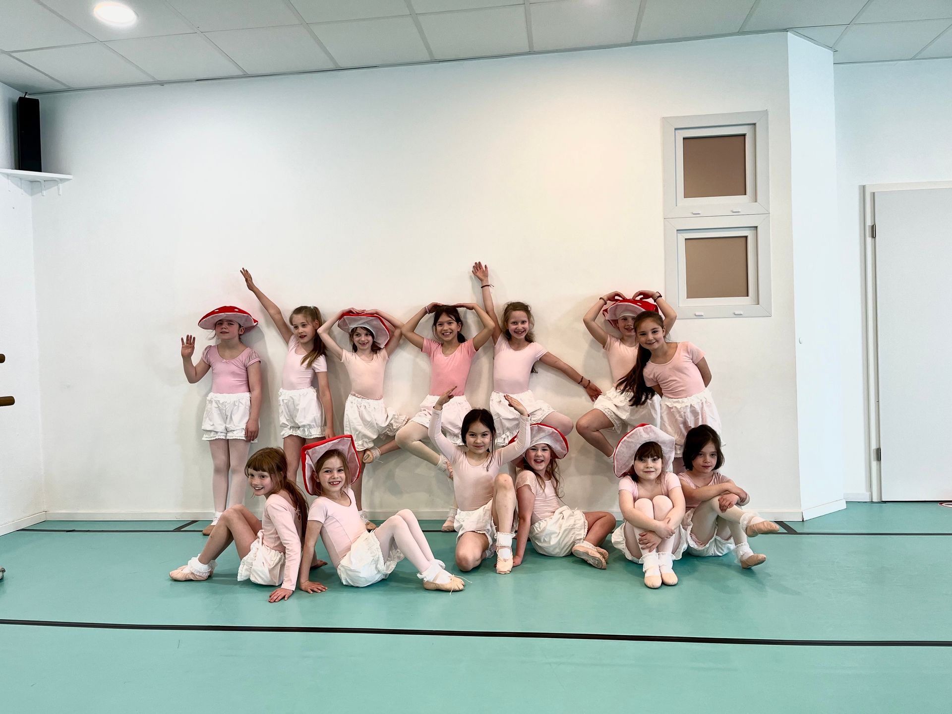 Eine Gruppe junger Mädchen posiert in einem Tanzstudio für ein Foto.
