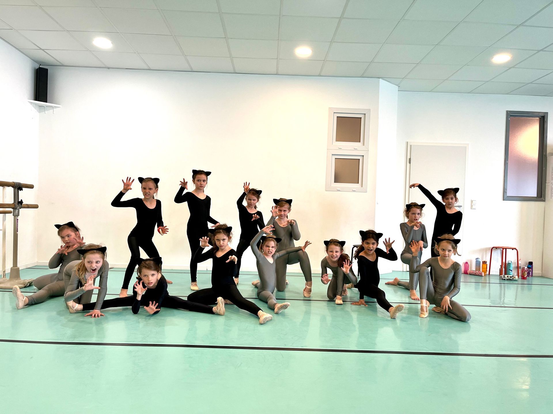 Eine Gruppe Kinder posiert in einem Tanzstudio für ein Foto.