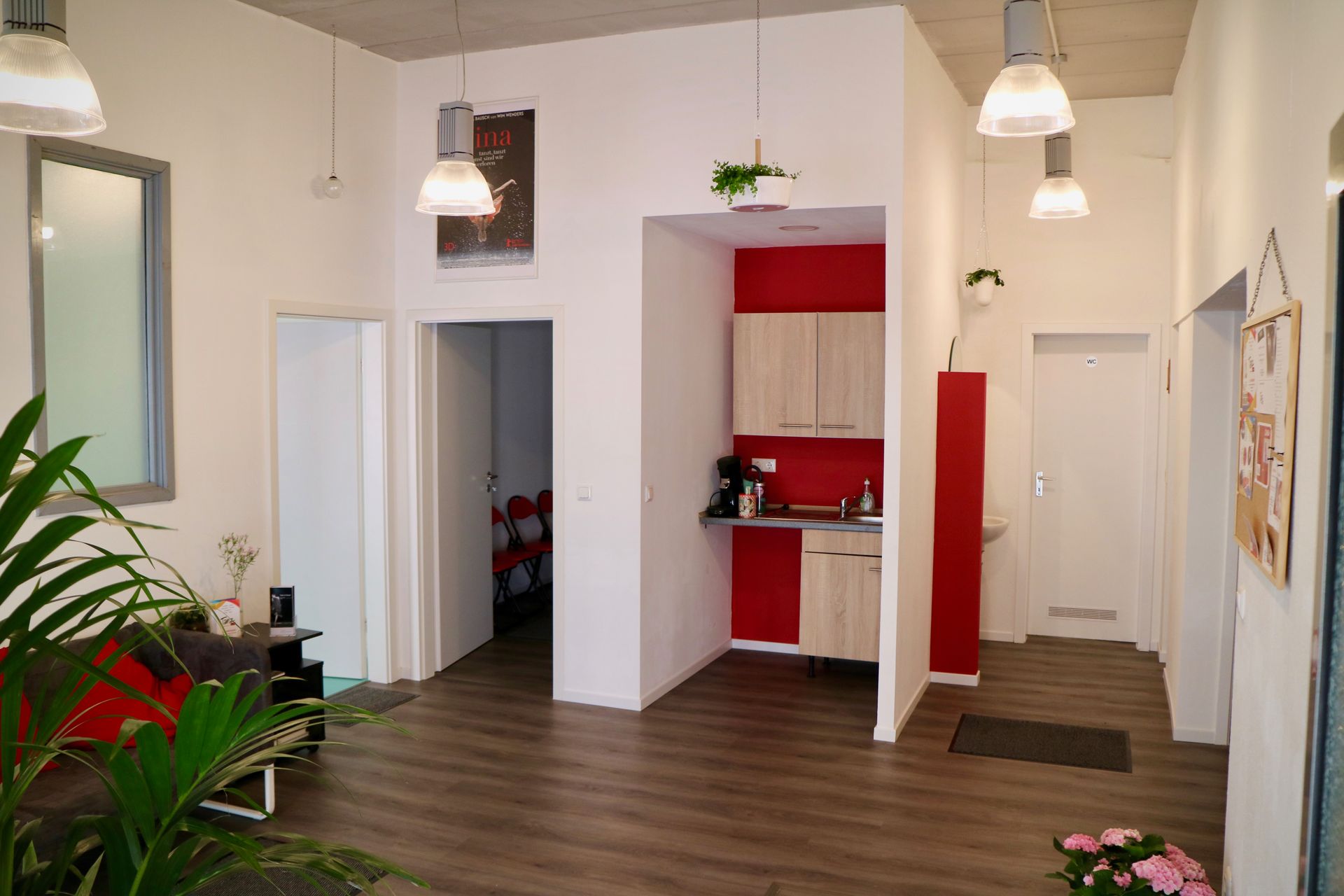 Ein Wohnzimmer mit Couch und im Hintergrund eine Küche.