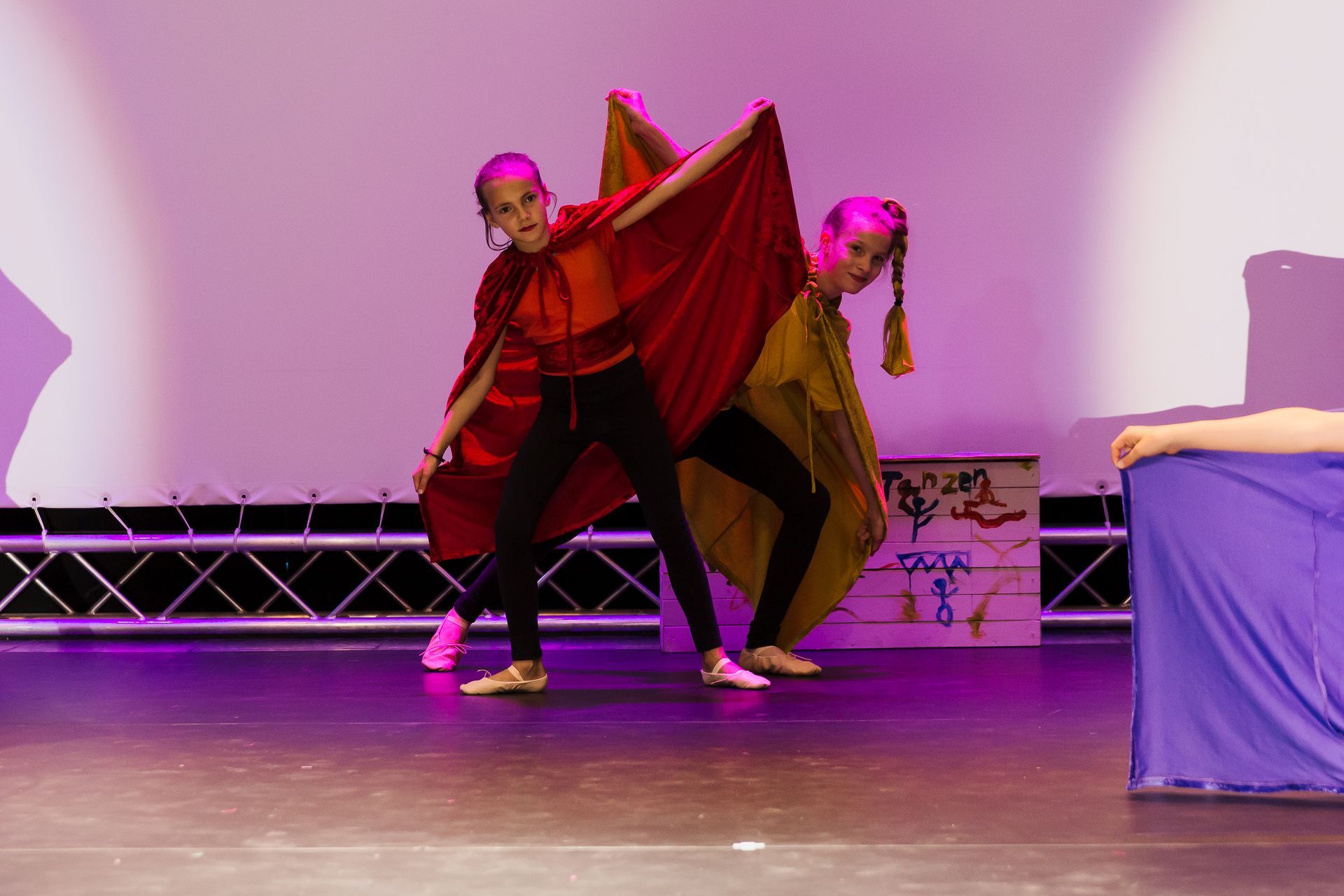 Zwei junge Mädchen tanzen auf einer Bühne.