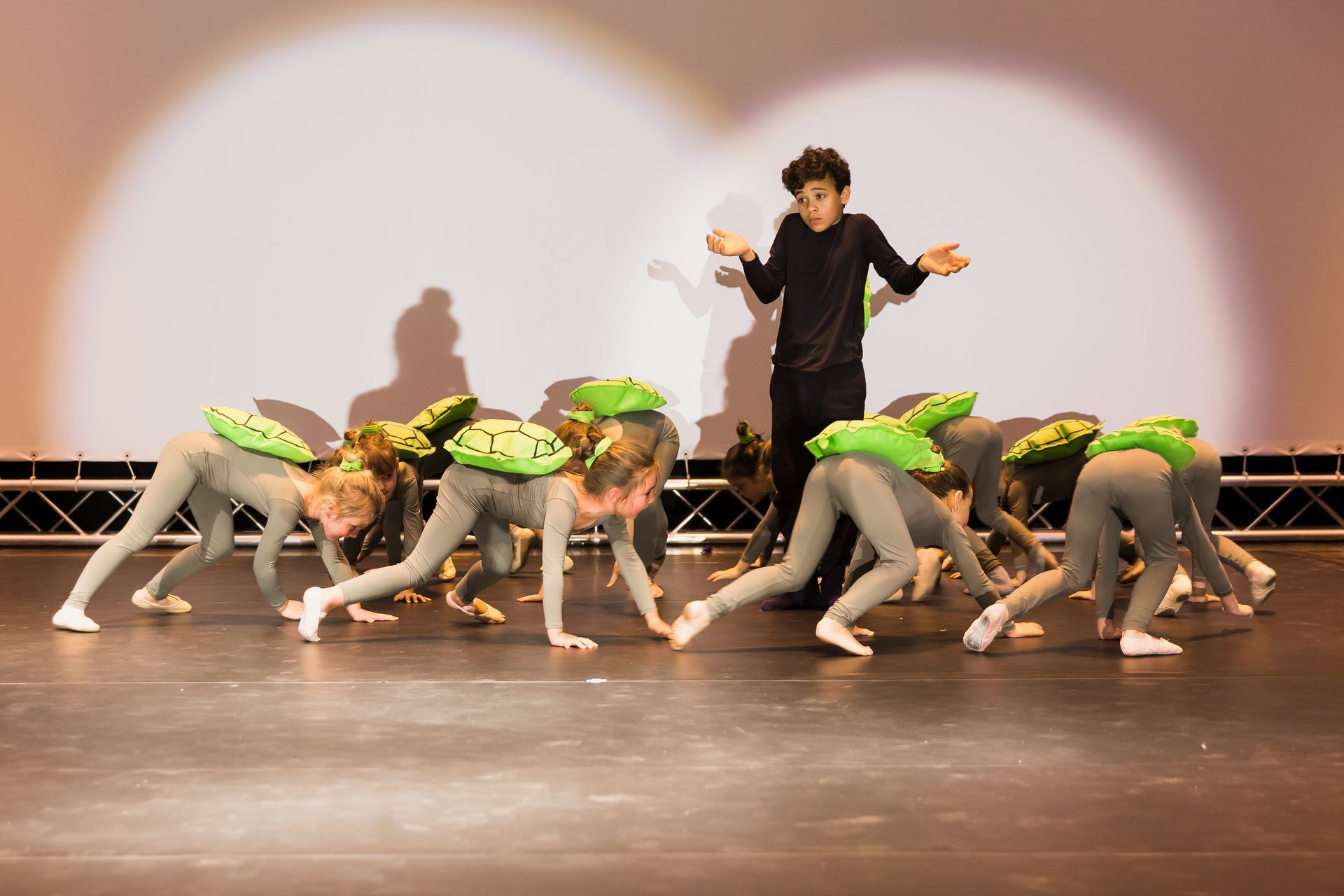 Eine Gruppe junger Mädchen führt auf einer Bühne einen Tanz auf.