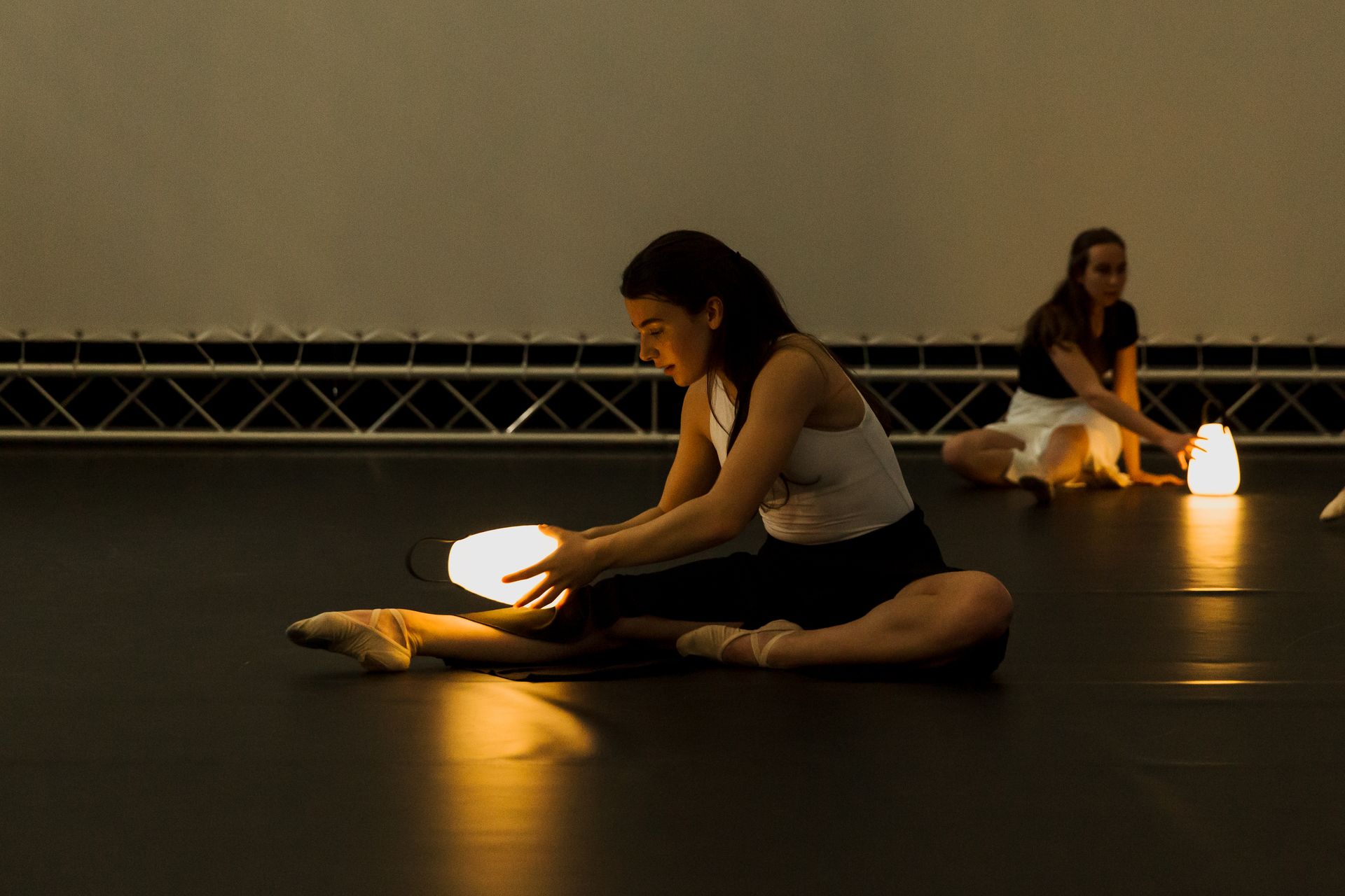 Eine Frau sitzt auf dem Boden und hält eine Lampe.