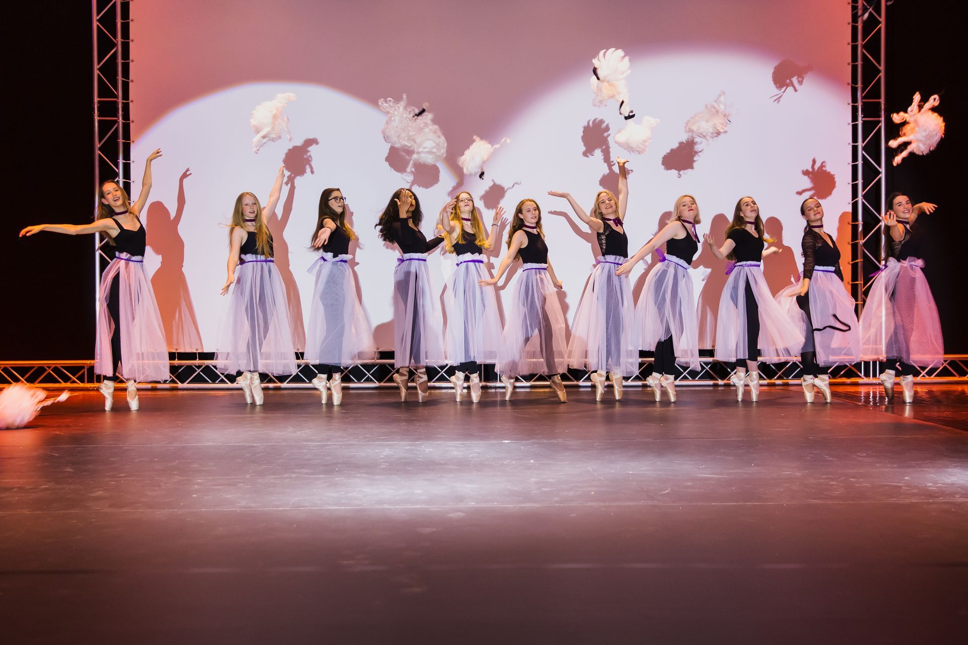 Eine Gruppe junger Frauen tanzt auf einer Bühne.