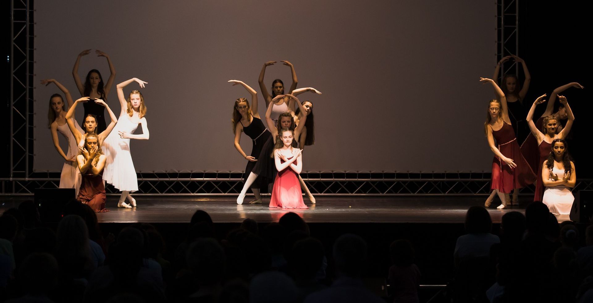 Eine Gruppe junger Frauen tanzt auf einer Bühne vor einem Publikum.