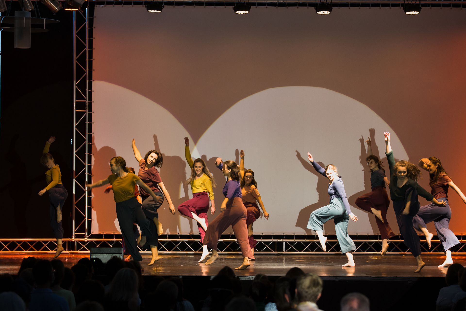 Eine Gruppe von Menschen tanzt auf einer Bühne vor einem Publikum.