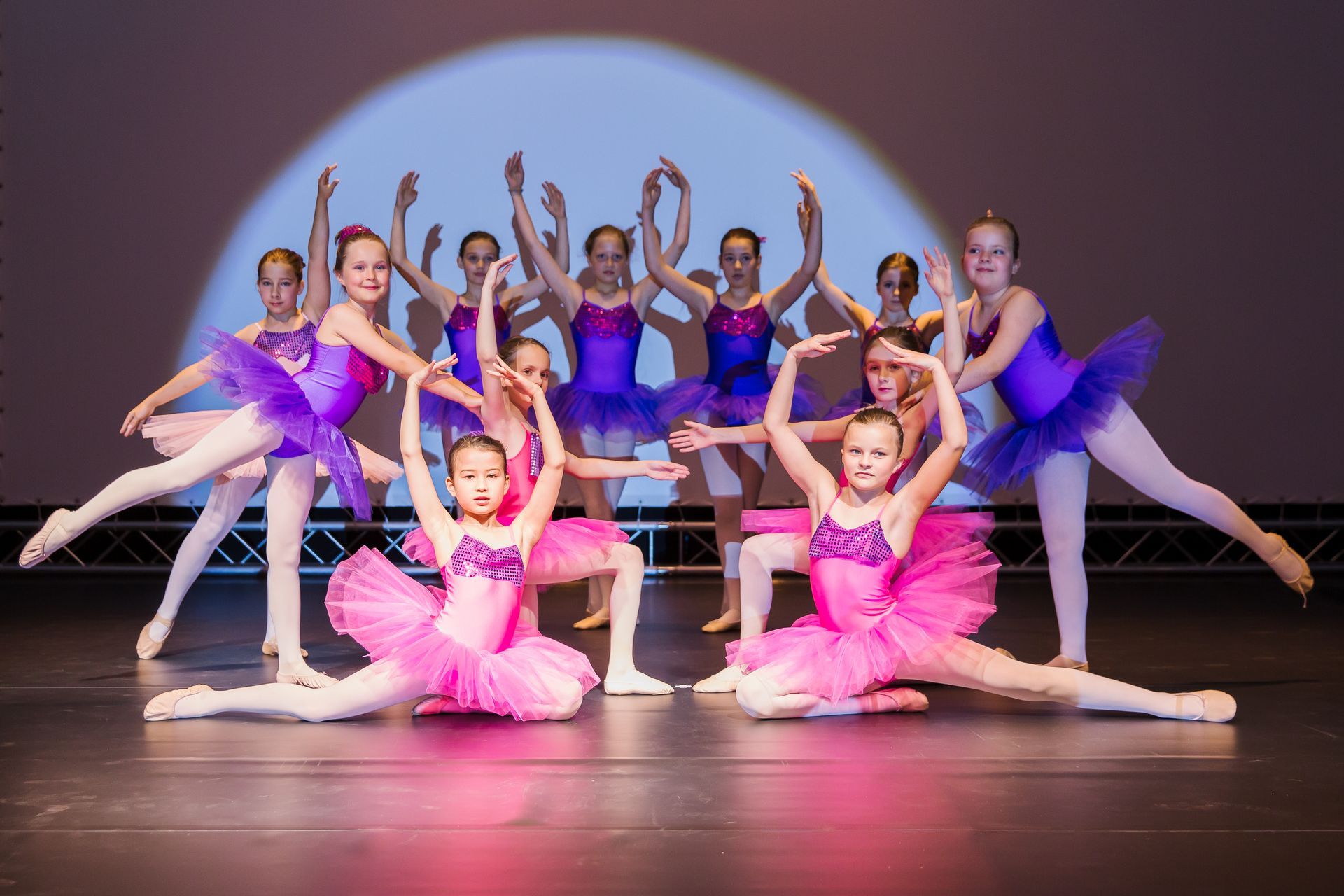 Eine Gruppe junger Ballerinas tritt auf einer Bühne auf.