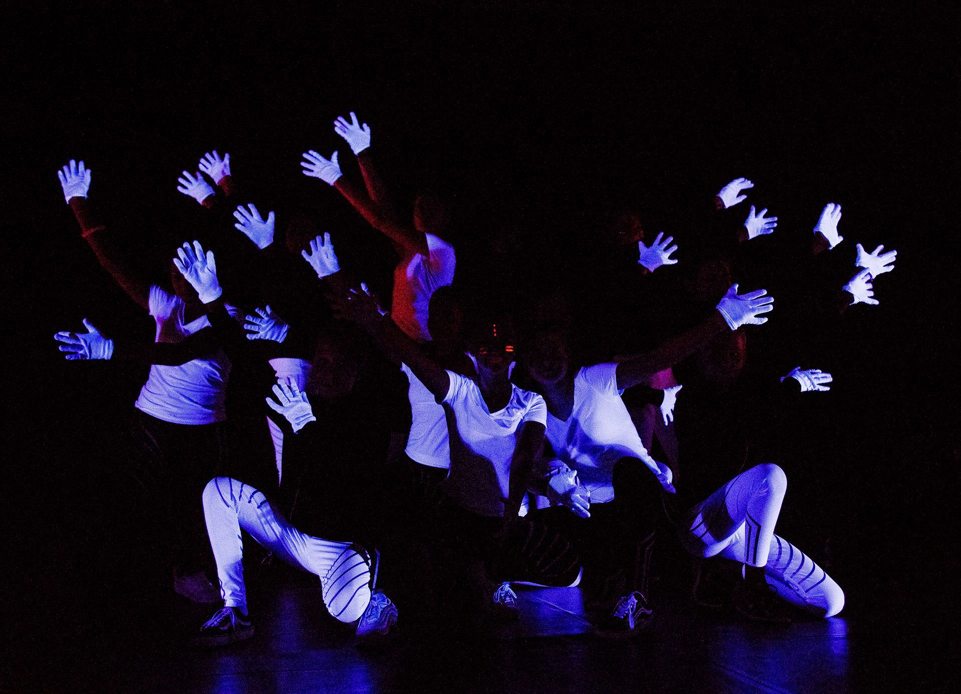 Eine Gruppe von Menschen, die im Dunkeln leuchtende Handschuhe tragen.