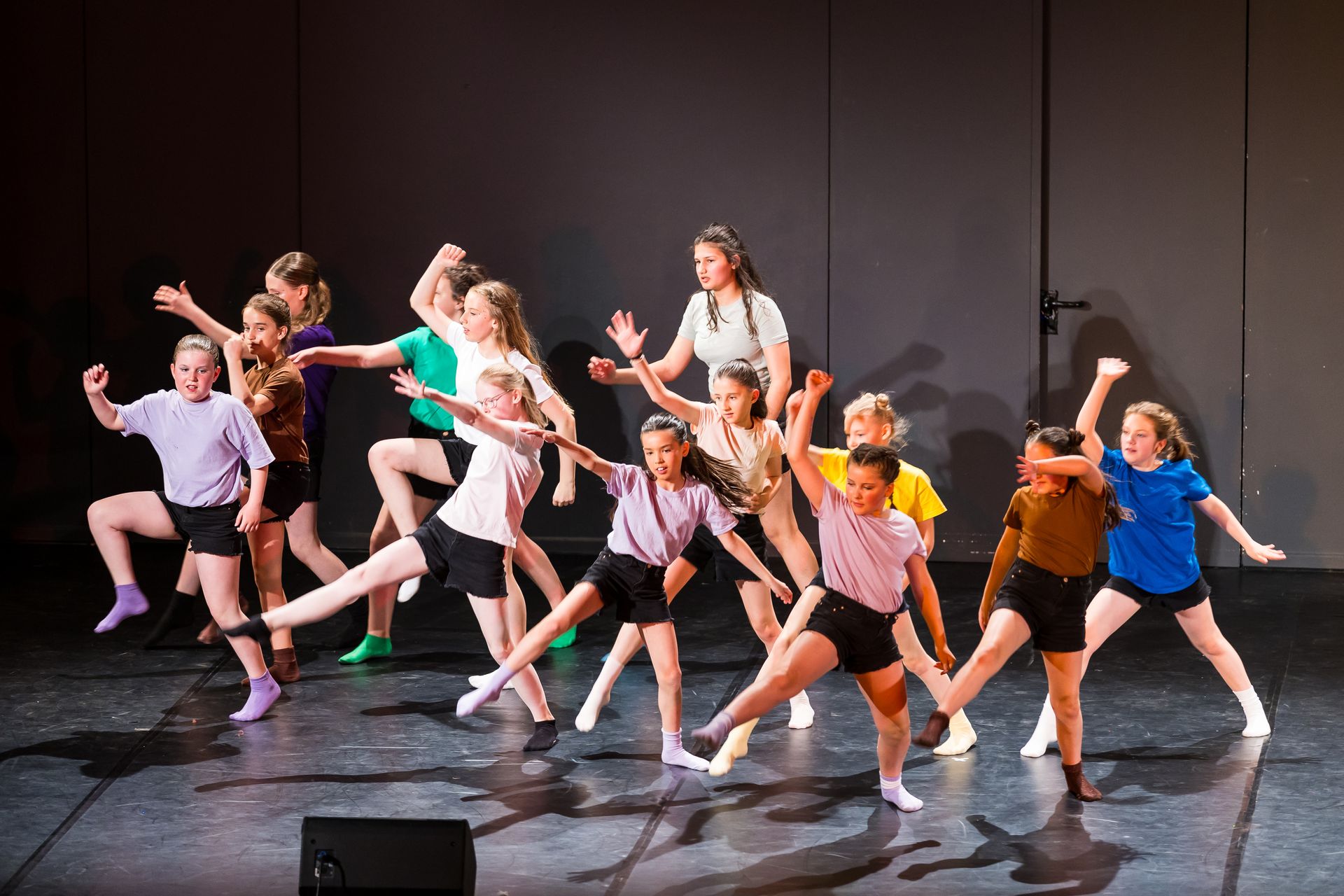 A group of young girls are dancing on a stage.