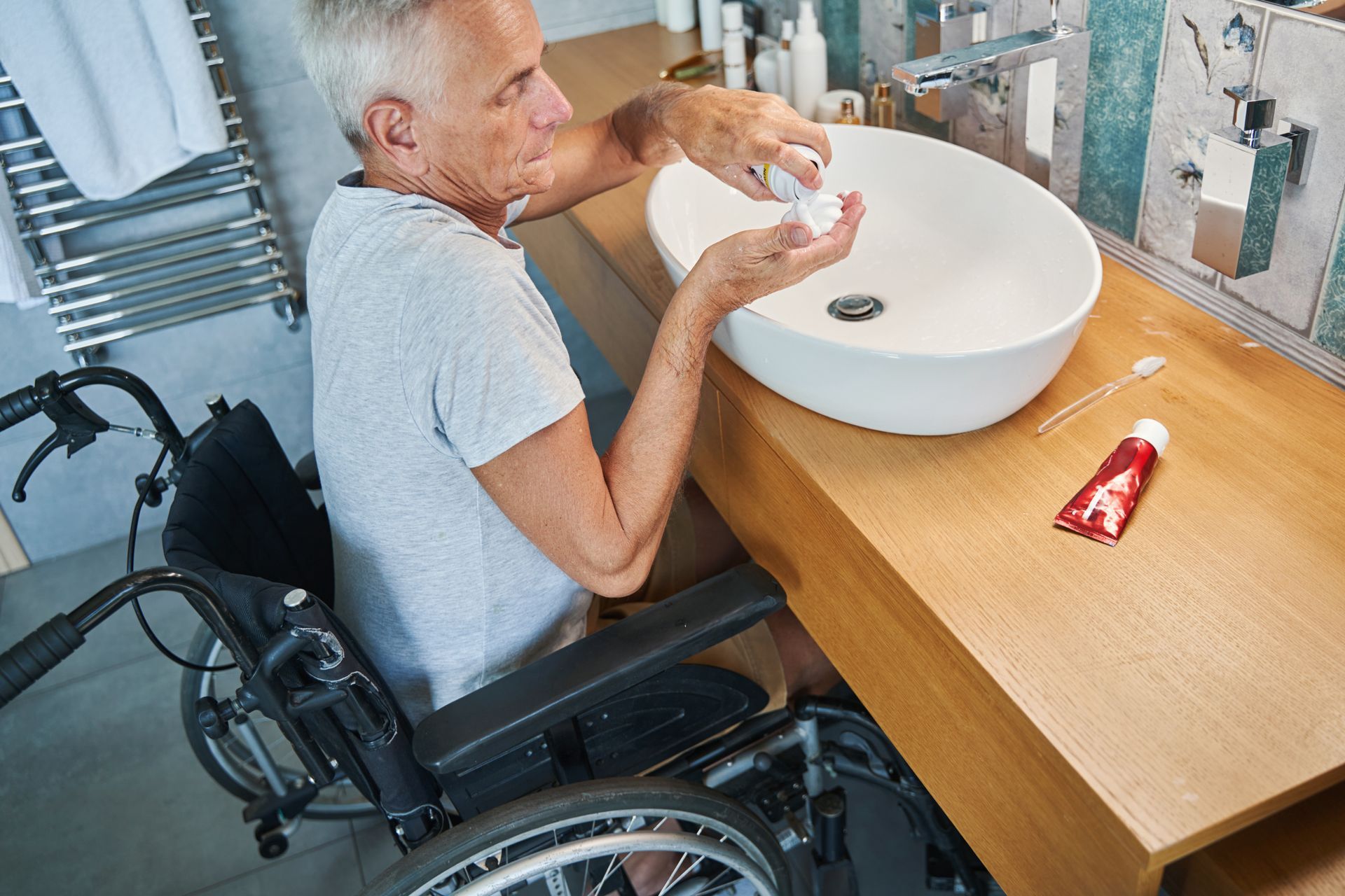 Homme en fauteuil roulant dans sa salle de bains