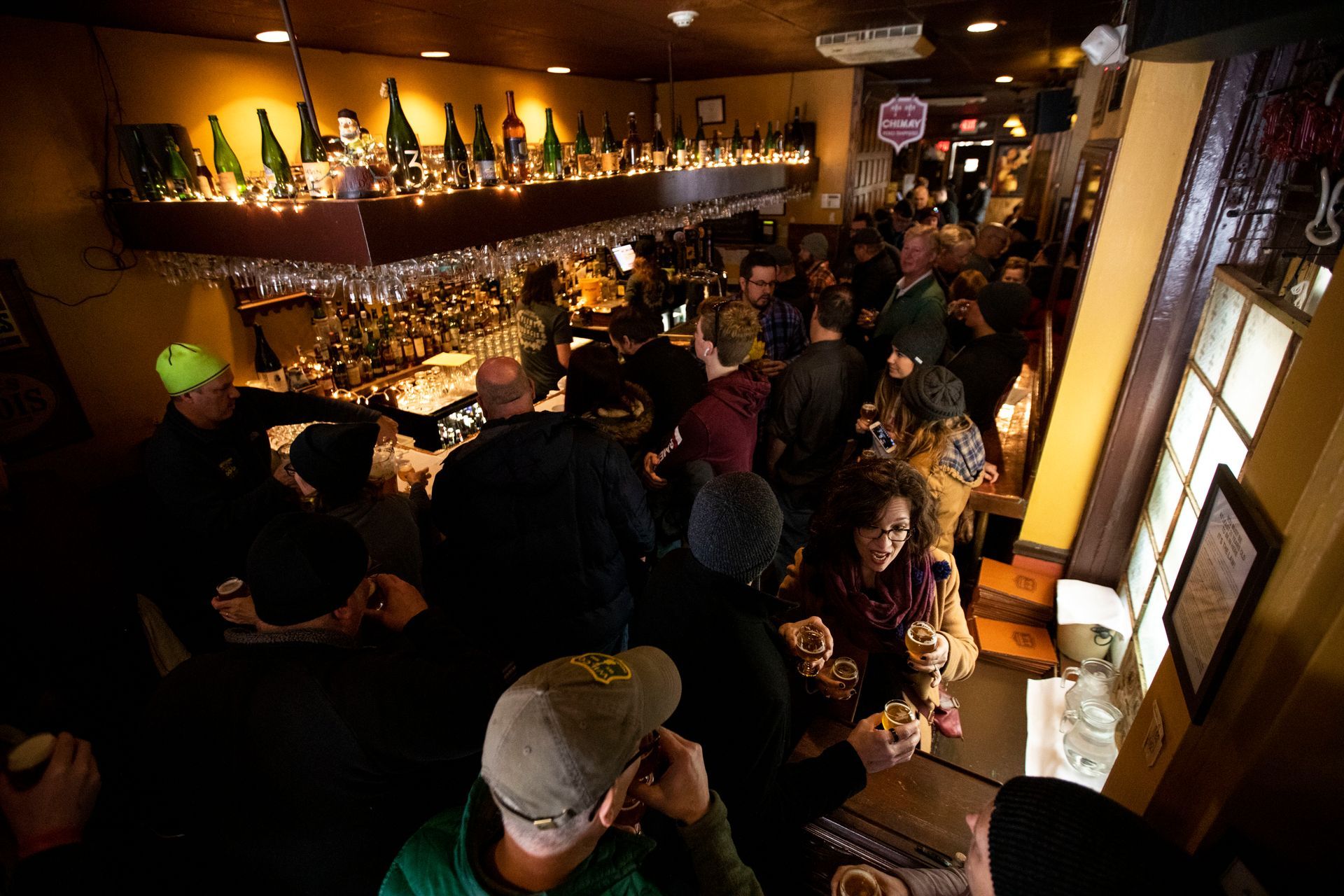 A group of people are sitting at tables in a bar
