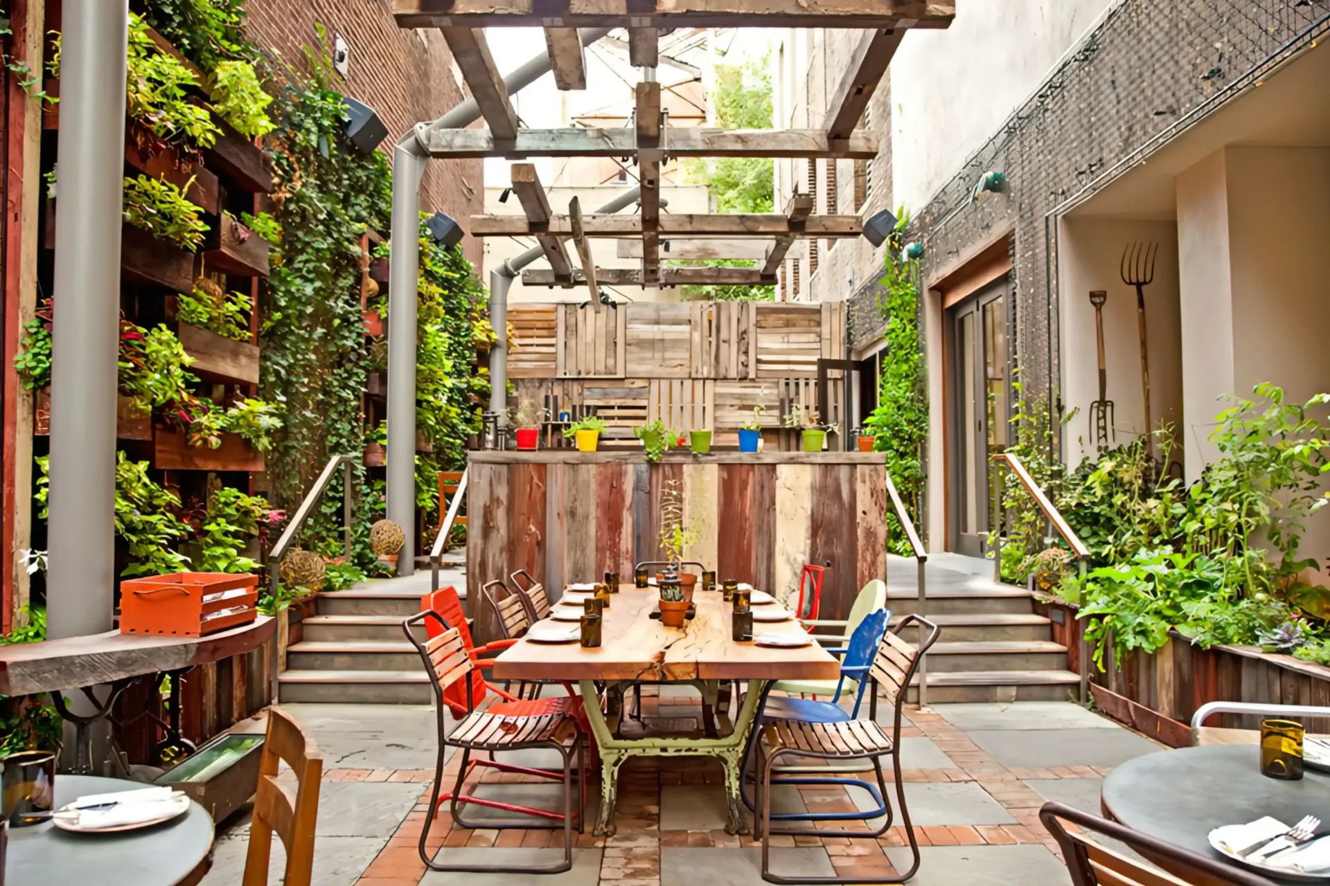 A patio with tables and chairs and a table with plates on it