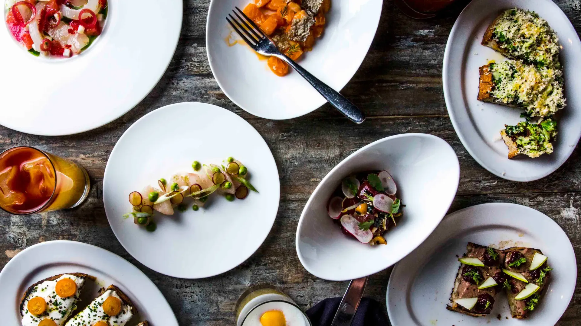 A table topped with plates of food and a fork.