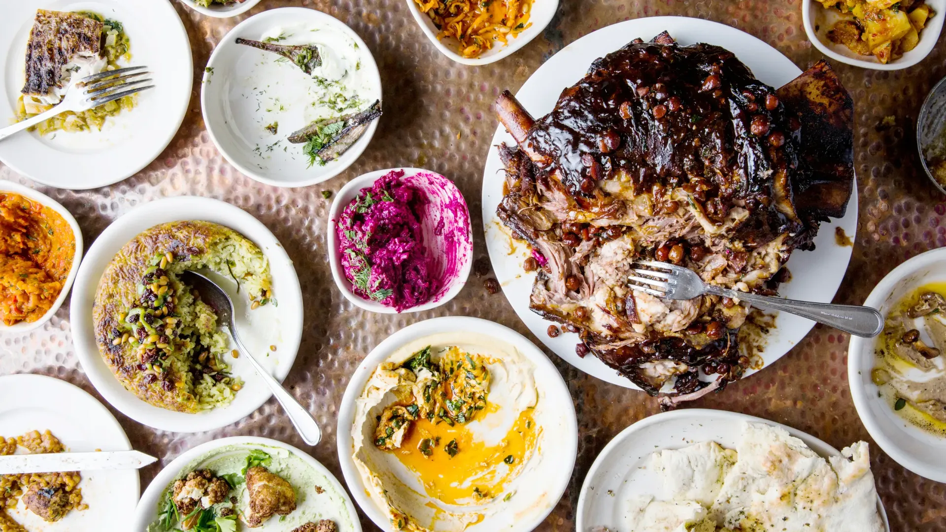 A table topped with plates of food and bowls of food.