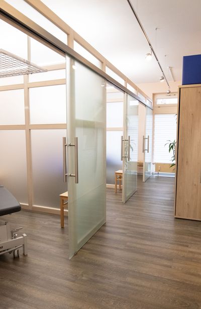 Milchglas-Schiebetüren in einem modernen Interieur mit Holzböden und -rahmen.