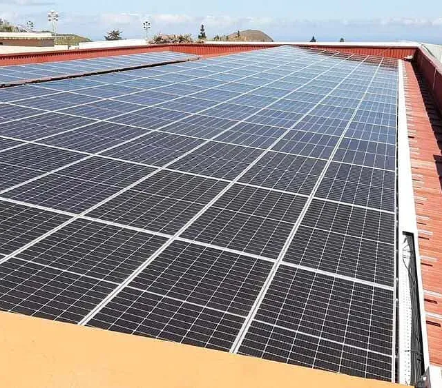 Paneles solares instalados en un techo de tejas rojas, generando energía solar.