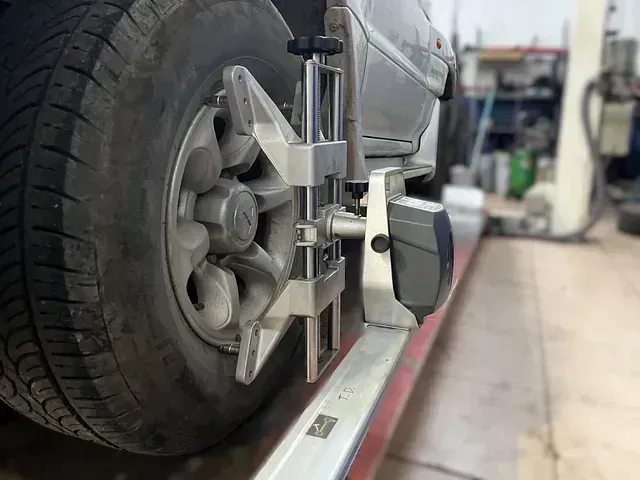 Se está alineando un coche con una máquina en un garaje.