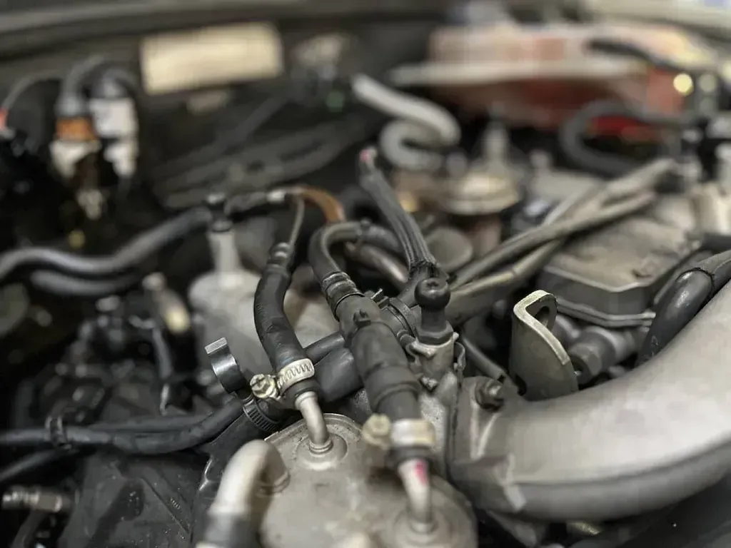 Un primer plano de un motor de automóvil con muchos cables saliendo de él.