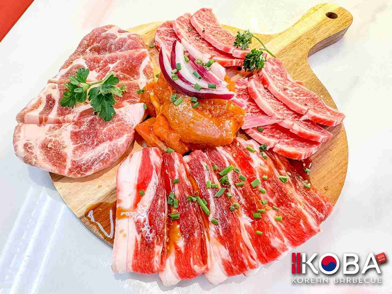 Plato de barbacoa coreano: diversos cortes de carne cruda dispuestos sobre una tabla de madera.