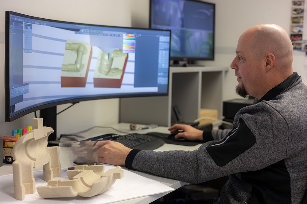 Eine dunkelgraue, 3D-gedruckte Box mit baumartigen Stützen. Die Box hat eine abgerundete Oberseite und einen einzelnen Knopf.