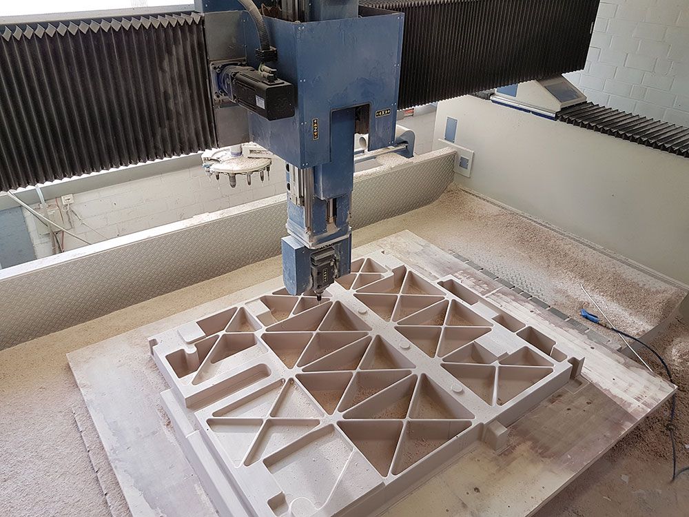 CNC-Maschine schneidet geometrische Formen aus Holz.