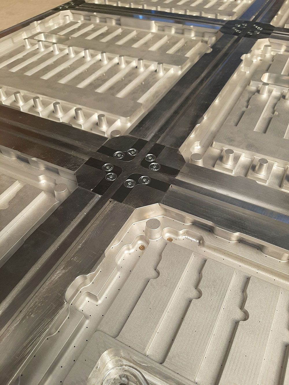 Nahaufnahme einer Metallkonstruktion mit sich kreuzenden, mit Bolzen befestigten Trägern.