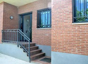 Un edificio de ladrillo con escaleras que conducen a la puerta.