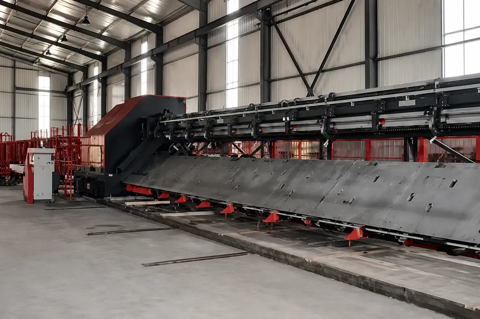 Gran máquina industrial con una larga cinta transportadora en el interior de una fábrica con aspecto de almacén.