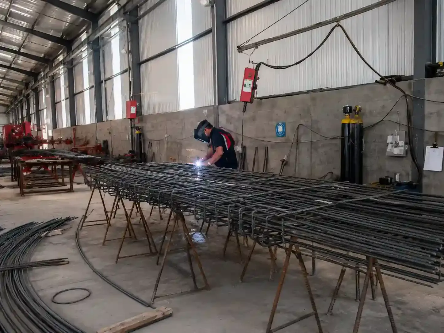 Máquina de corte industrial lanzando chispas sobre una pieza de metal en un taller oscuro.