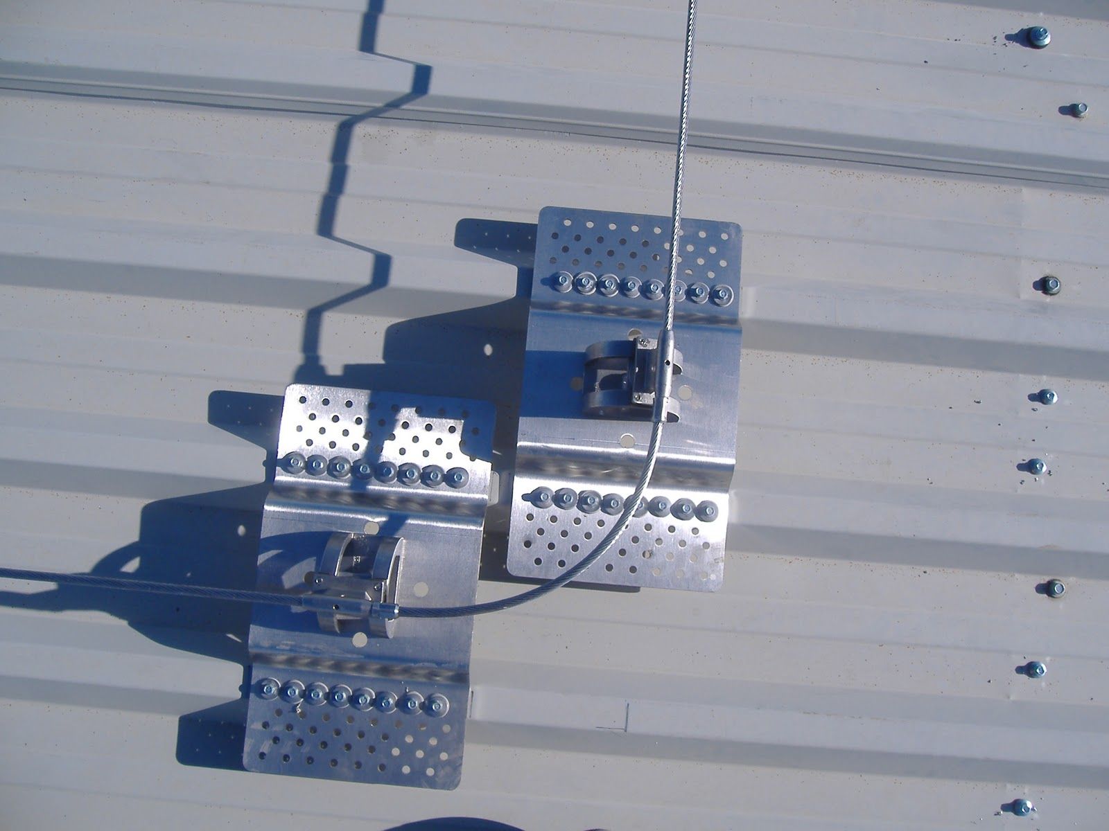 Sistema de anclaje de techo metálico instalado en un techo de metal corrugado.