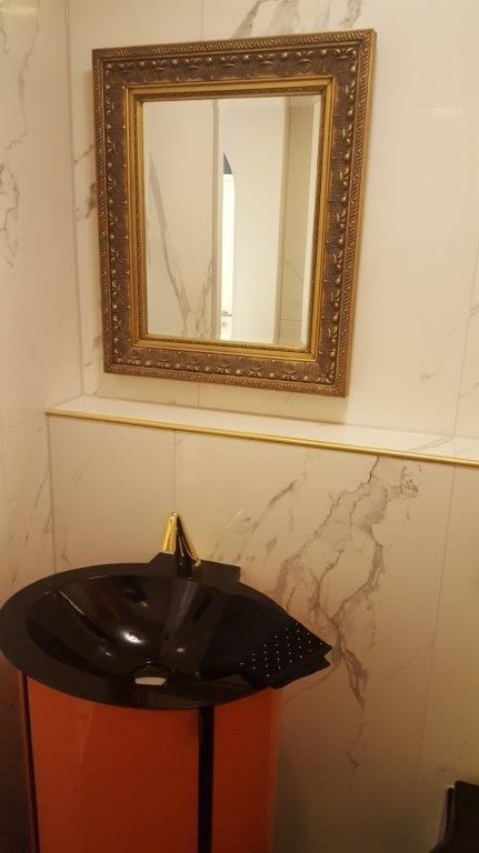 Ein Badezimmer mit Waschbecken und Spiegel an der Wand.