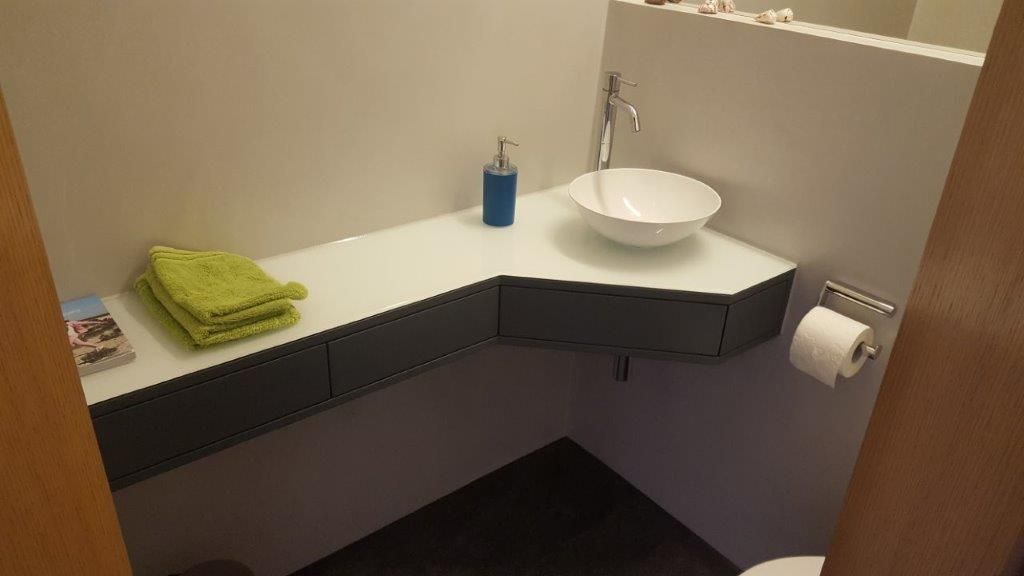 Ein Badezimmer mit Waschbecken, Toilette und Handtüchern auf der Ablage.