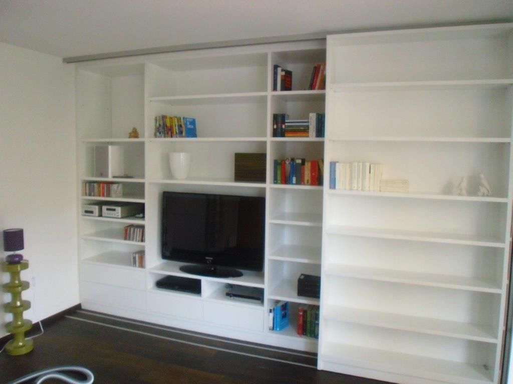 Ein Wohnzimmer mit weißen Regalen und einem Flachbildfernseher