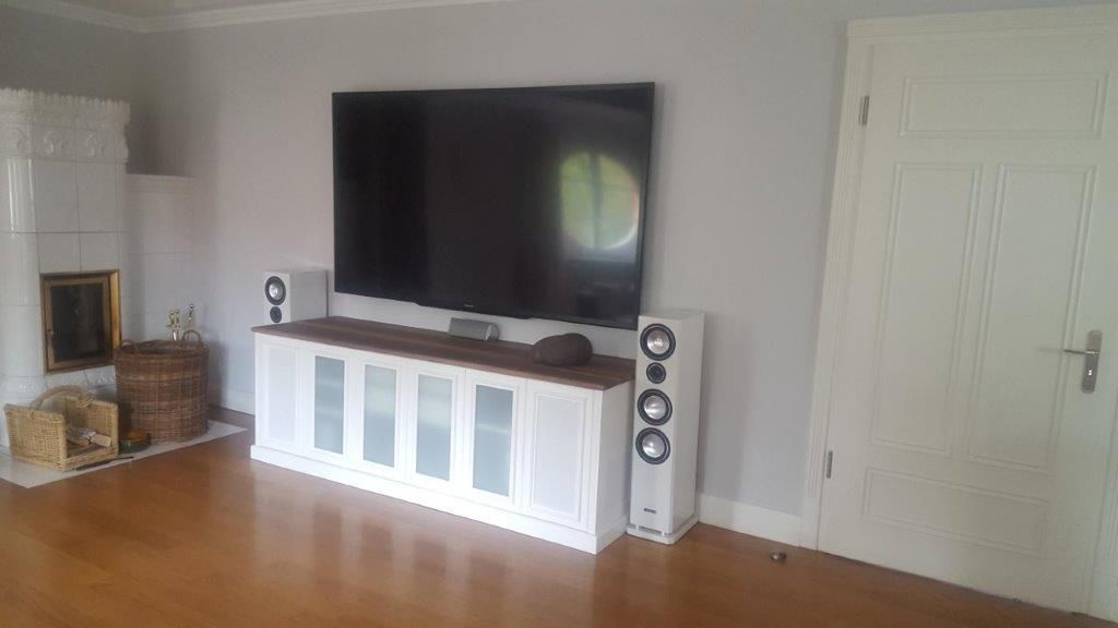 Ein Wohnzimmer mit Flachbildfernseher und Lautsprechern.