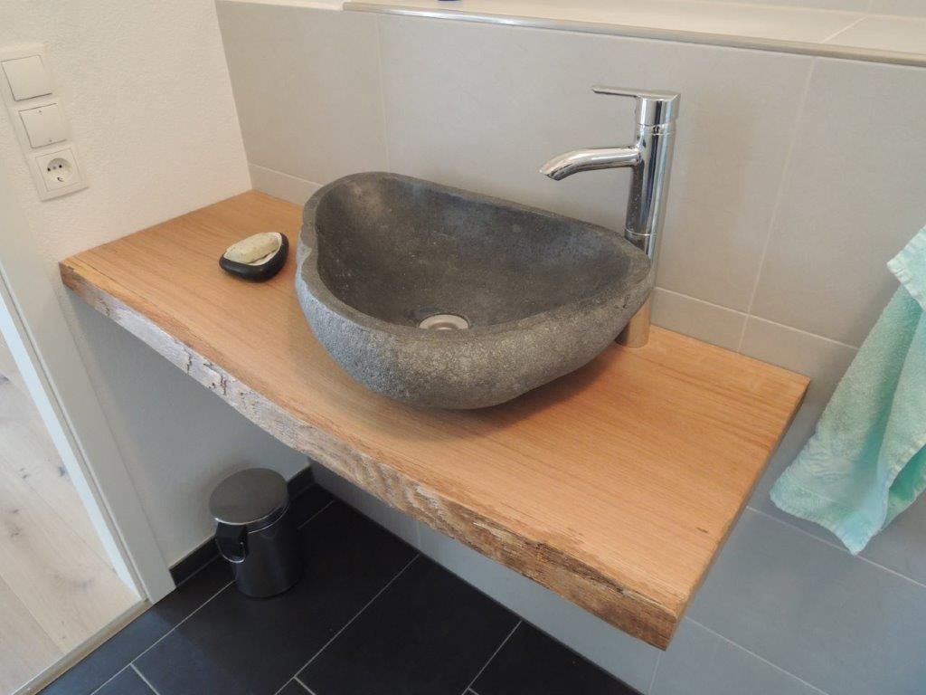 Ein Waschbecken steht auf einer Holzablage.