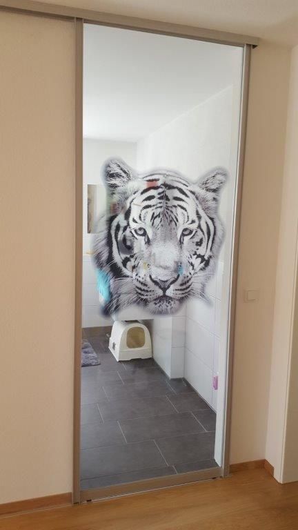 Eine Glasschiebetür mit einem Tigerbild darauf.