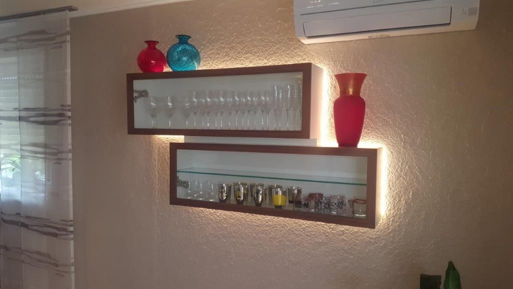 Ein Wohnzimmer mit zwei Regalen voller Gläser und Vasen.