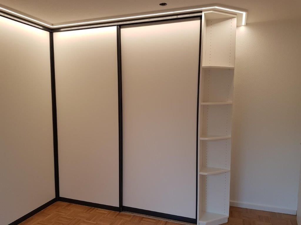 In der Ecke des Zimmers steht ein Schiebetürenschrank.