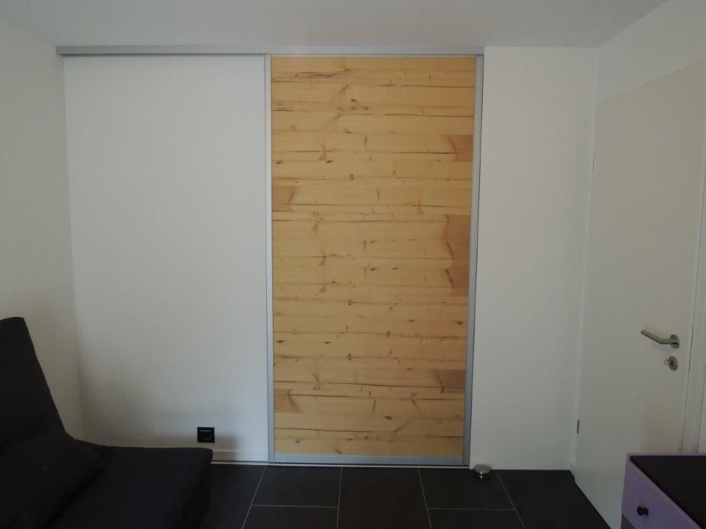 Ein Zimmer mit einer Holzschiebetür und einer Couch