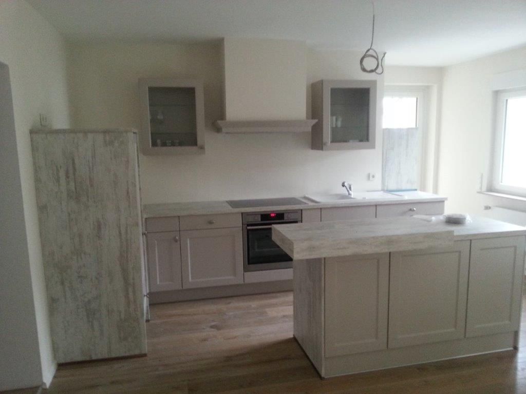 Eine Küche mit weißen Schränken und einer großen Insel in der Mitte