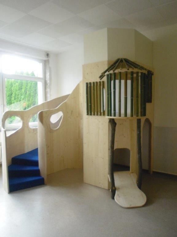 Ein hölzernes Spielhaus mit einer Treppe, die hinaufführt