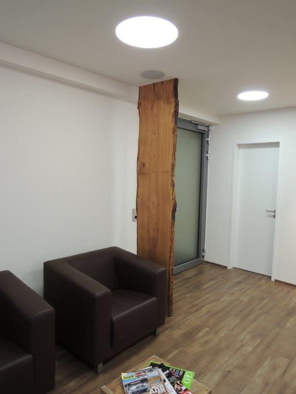 Ein Wartezimmer mit zwei Stühlen und einem Tisch mit Zeitschriften darauf